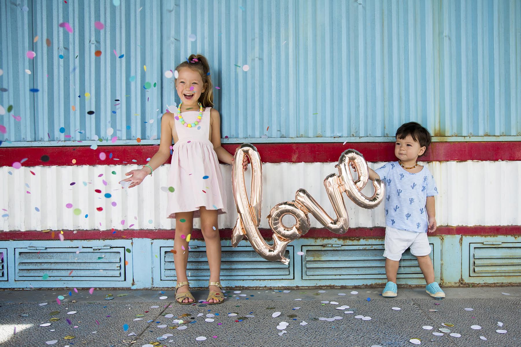 a boy and girl holding love balloon