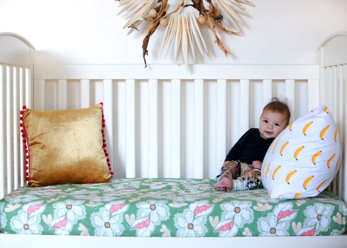 young boy on white wood cot